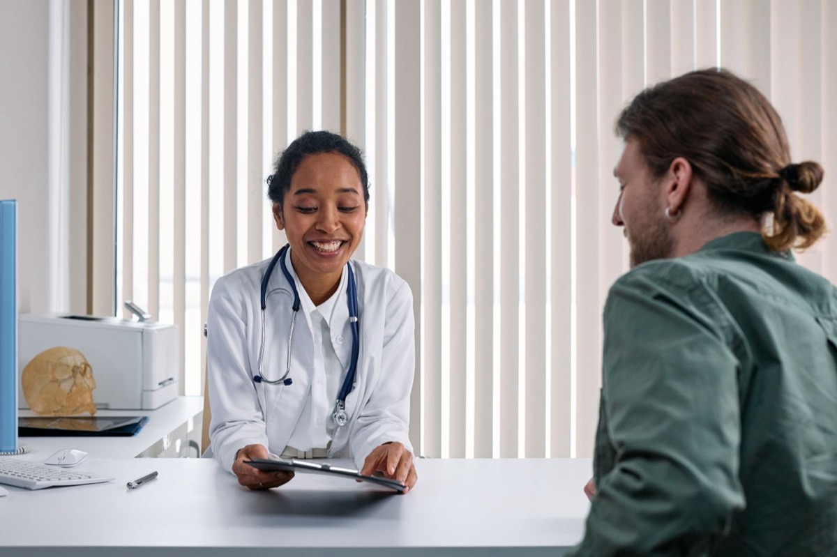 Doctora atendiendo a un paciente en su consultorio